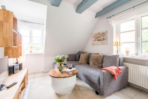 ein Wohnzimmer mit einem Sofa und einem Tisch in der Unterkunft Harderslebener Strasse 33b in Westerland
