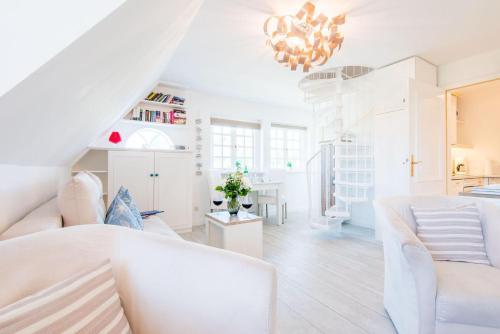 a living room with white furniture and a chandelier at Nuur Hiir Hues Whg 4 in Kampen