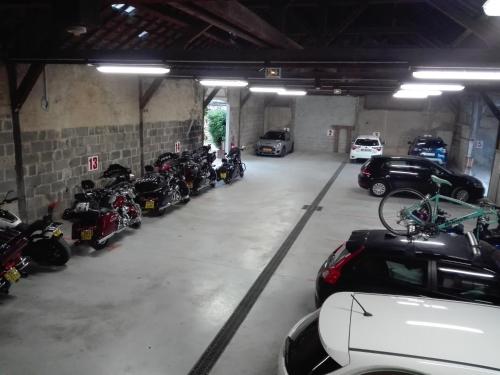 a garage with motorcycles and cars parked in it at Beaune Hôtel in Beaune