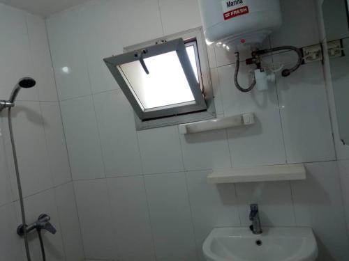 a bathroom with a window and a toilet and a sink at Appartement Beau Séjour 1 in Dakar