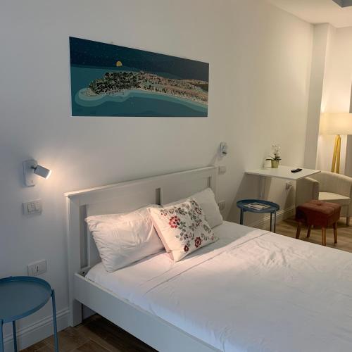 1 dormitorio con 1 cama blanca y 2 sillas azules en Sa Conca, en Cagliari