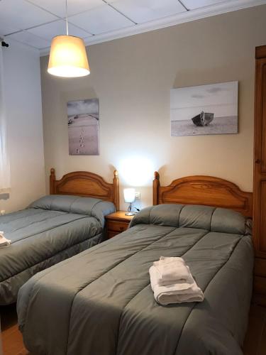 a bedroom with two beds and a towel on the bed at El Paseo ATV in Riópar