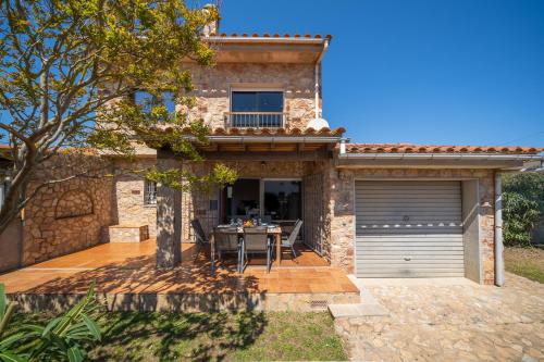 a stone house with a patio and a garage at Villa Paulina in Sant Martí d'Empúries