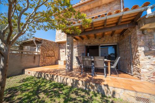 a patio of a house with a table and chairs at Villa Paulina in Sant Martí d'Empúries