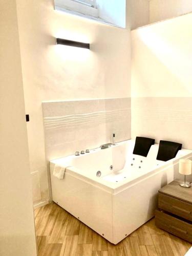 a white bathroom with a tub and a sink at Pigneto Square Home in Rome