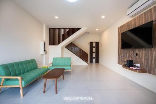 a living room with a green couch and a tv at 我們這一家輕旅宿 in Xiaoliuqiu