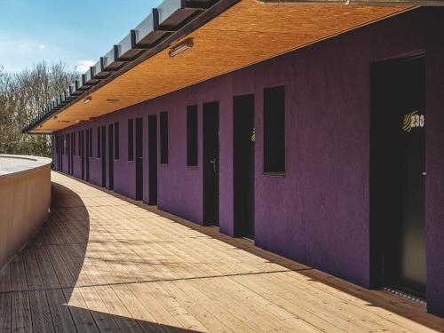 a row of doors on a purple building at Eklo Marne La Vallée in Serris