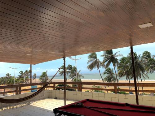 a room with a pool table and a hammock and a beach at Temporada Litorânea slz in São Luís