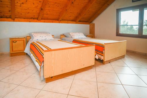 a bedroom with two beds and a window at House Zelanto Mali in Tkon