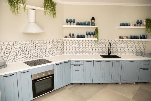 a kitchen with white cabinets and a stove top oven at Casa Anabeca in Baile Felix