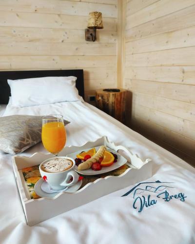 a tray of food and a cup of coffee on a bed at Vila Breg Zlatibor in Zlatibor