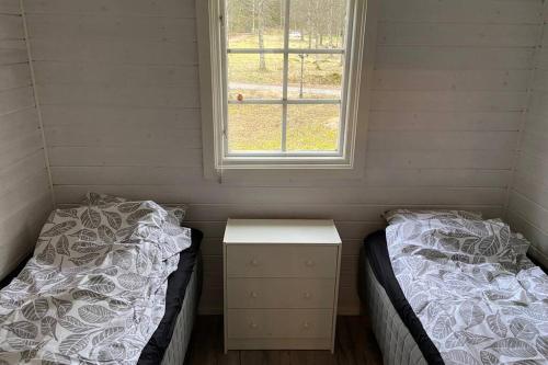 a small room with two beds and a window at Ryasjö Holiday Homes in Sexdrega