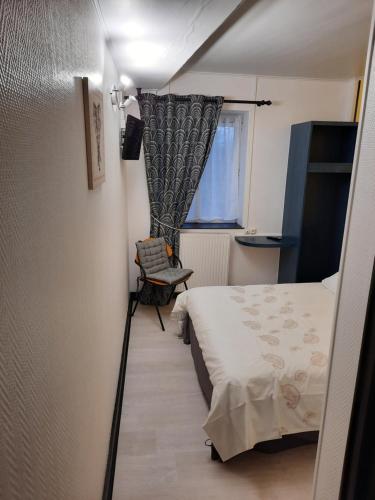 LaivesにあるLe Ch'ti Bourguignonのベッドと窓が備わる小さな客室です。
