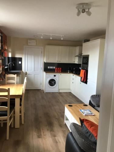 a kitchen and living room with a table and a dining room at Suil Na Mara Studio in Lochinver