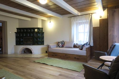 sala de estar con sofá y chimenea en Falusi Vendégház en Etyek