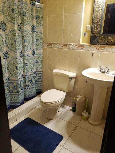 La salle de bains est pourvue de toilettes et d'un lavabo. dans l'établissement Hostal Rudy's Beach, à Puerto Cortes