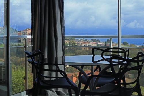 twee stoelen en een tafel voor een raam bij Mare e Vista in Ajaccio