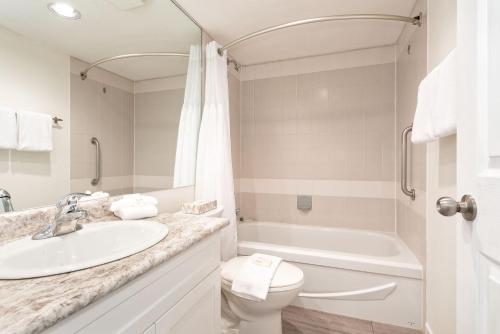 a bathroom with a sink and a toilet and a tub at Lake Placid Lodge by Whiski Jack in Whistler