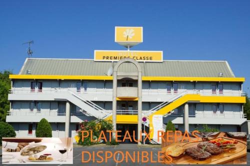 a building with a table of food in front of it at Premiere Classe Laon in Laon