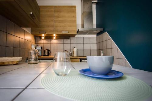 une tasse et un verre sur un comptoir dans une cuisine dans l'établissement Marin Malouin,à 2 pas de la mer & d'intra muros, proche gare., à Saint-Malo