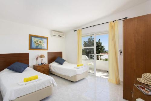 1 dormitorio con 2 camas y balcón en Villa Animado by Villa Plus, en Albufeira