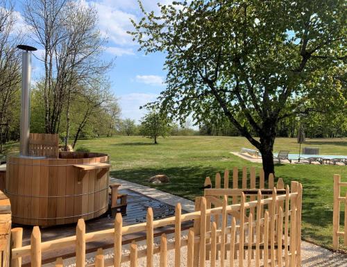 a wooden fence with a wooden tub in a park at Manoir de Malagorse in Cuzance