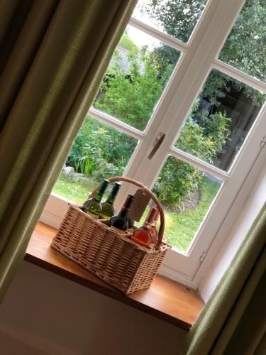 a basket of wine sitting on a window sill at Walnut Tree Gite Brittany in Boderel