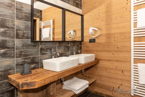 een badkamer met een wastafel en een spiegel bij Gîtes de Moyenmont in La Bresse
