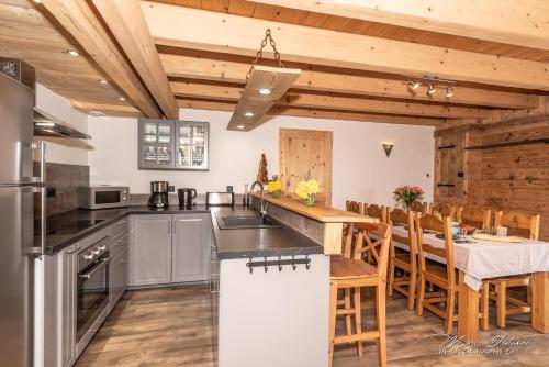 une cuisine et une salle à manger avec une table et des chaises dans l'établissement Gîtes de Moyenmont, à La Bresse