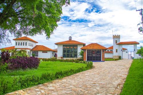 uma grande casa branca com telhados laranja em CASA BOHEMIA - Hotel Spa Viñedo Cervecería Restaurante Piscina em Campoalegre