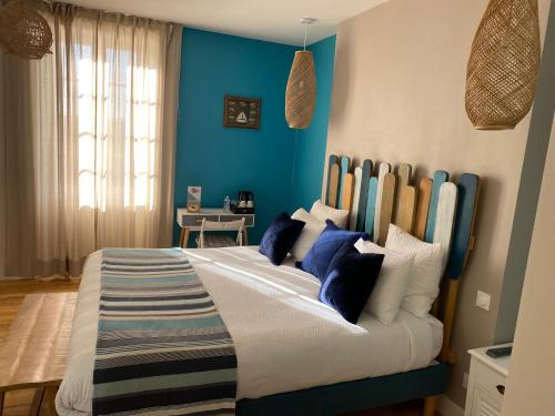 a bedroom with a large bed with blue walls at La Rochelle et l'Aunis in Saint-Sauveur-dʼAunis