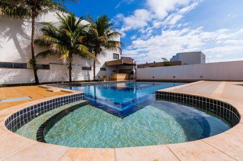 a swimming pool with blue water and palm trees at Hotel Londri Star in Londrina