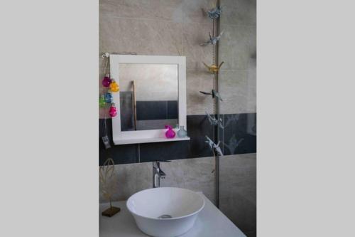 y baño con lavabo blanco y espejo. en Ti-punch T3 climatisé Manapany les bains en Manapany-les Bains