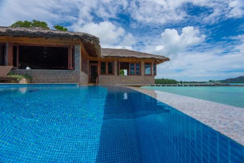 a swimming pool in front of a villa at Chalets Cote Mer in Baie Sainte Anne