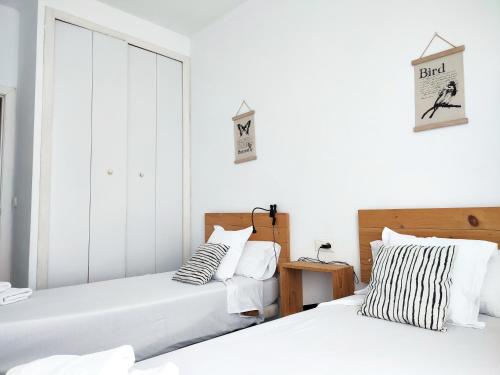 two beds in a bedroom with white walls at Flats Friends Torres Quart in Valencia