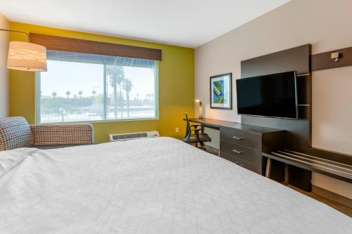 a hotel room with a bed and a flat screen tv at Holiday Inn Express & Suites - Phoenix Dwtn - State Capitol by IHG in Phoenix
