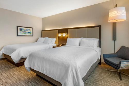 a hotel room with two beds and a chair at Holiday Inn Express & Suites - Phoenix Dwtn - State Capitol by IHG in Phoenix