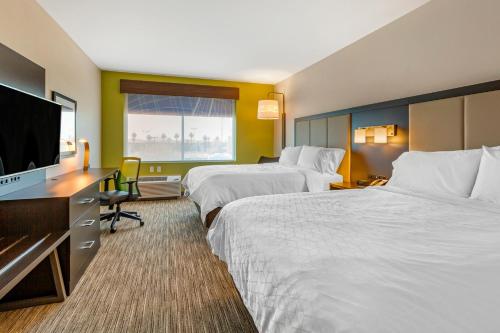 a hotel room with two beds and a flat screen tv at Holiday Inn Express & Suites - Phoenix Dwtn - State Capitol by IHG in Phoenix
