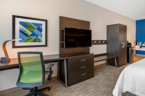 a hotel room with a bed and a desk with a television at Holiday Inn Express & Suites - Phoenix Dwtn - State Capitol by IHG in Phoenix