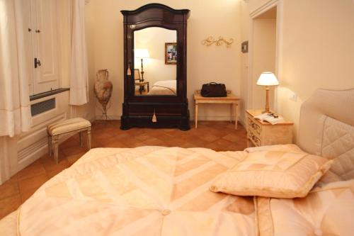 a bedroom with a large bed and a mirror at Villa Alba d'Oro - Historic luxury villa in Amalfi