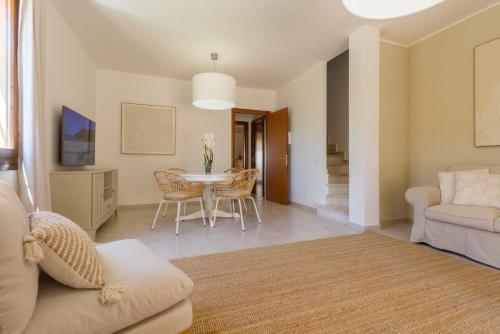 a living room with a table and chairs at °° VILLA ANNA°° in Villasimius