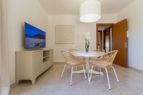 a dining room with a white table and chairs at °° VILLA ANNA°° in Villasimius