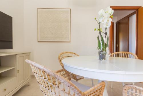 a white dining room with a white table and chairs at °° VILLA ANNA°° in Villasimius