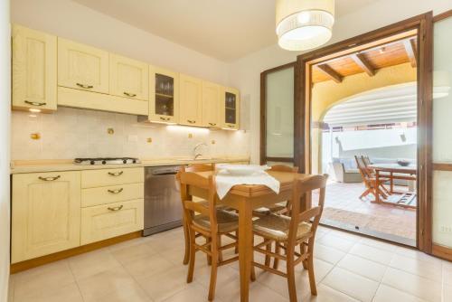 a kitchen with a wooden table and a dining room at °° VILLA ANNA°° in Villasimius