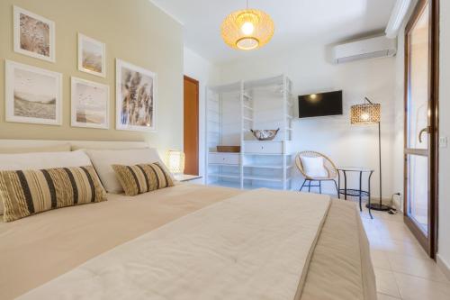 a bedroom with a large bed and a table at °° VILLA ANNA°° in Villasimius