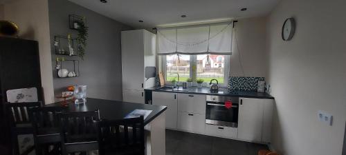 uma cozinha com uma mesa, um lavatório e uma janela em Wygodny Dom na Ponidziu z Basenem em Wiślica
