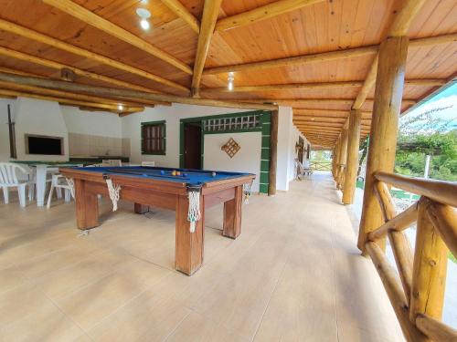 a pool table in a room with a wooden ceiling at Sítio Pedacinho do Céu na Serra Catarinense in Rancho Queimado