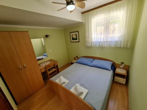 a small bedroom with a bed and a mirror at Apartments NEF in Pinezici