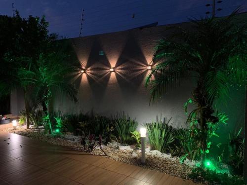 a wall with plants and lights in a building at Sobrado com 5 suítes para temporada e show rural in Cascavel