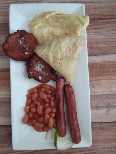 a plate of breakfast food with sausage beans and eggs at Diamond Plaza in Grand Anse